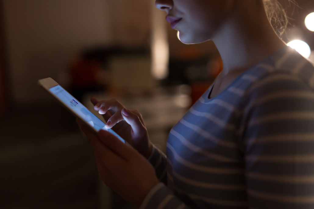 young female entrepreneur working on digital tablet in night office