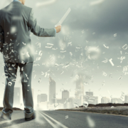 Back view of businessman reading documents in hand.