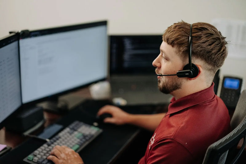 Sovran team member at PC work station with Mac device in the background.