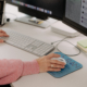 An office worker’s hands using a keyboard and mouse of a macOS system in a mixed environment.