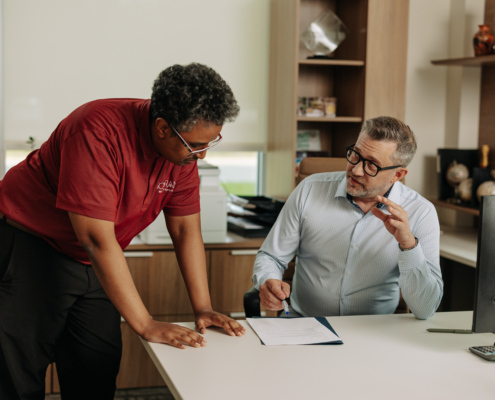 Sovran team member going over paperwork in a client office at a desk.