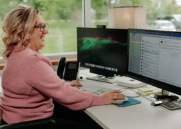 A woman using her computer mouse to view emails at work.