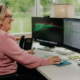 A woman using her computer mouse to view emails at work.