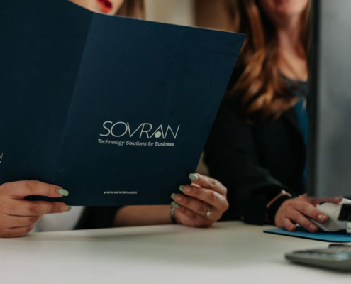 A woman holding a folder about technological solutions for businesses.