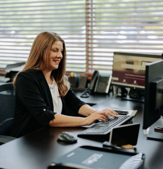 A female office worker typing on her computer.