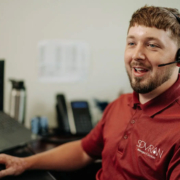 An IT helpdesk worker talking on a headset.