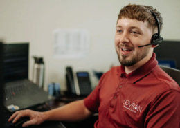 An IT helpdesk worker talking on a headset.