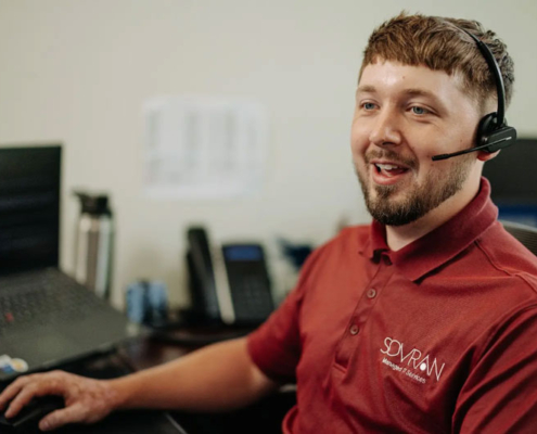 An IT helpdesk worker talking on a headset.