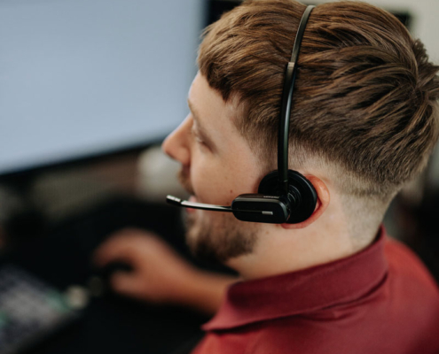 An IT Help Desk worker talking on a headset.