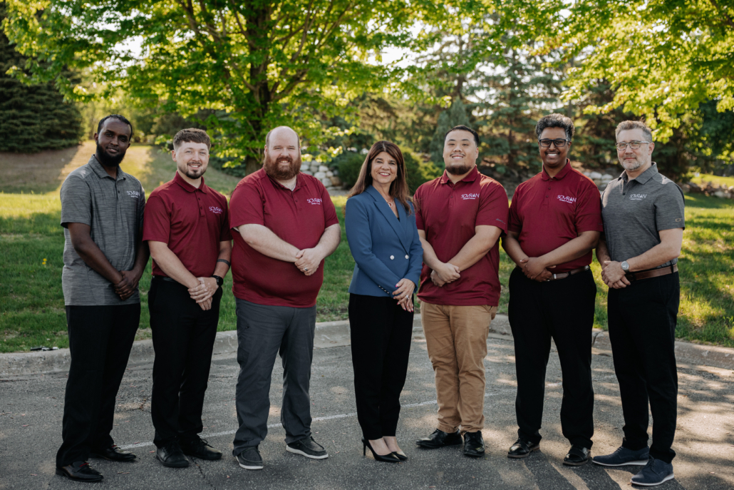 A team of office workers posing for a picture.
