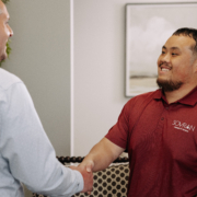 Two IT workers shaking hands in an office.