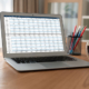 A laptop computer sitting on a table while displaying a spreadsheet.
