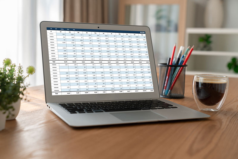 A laptop computer sitting on a table while displaying a spreadsheet.