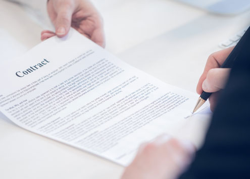 A businessman giving another man a contract to be signed.
